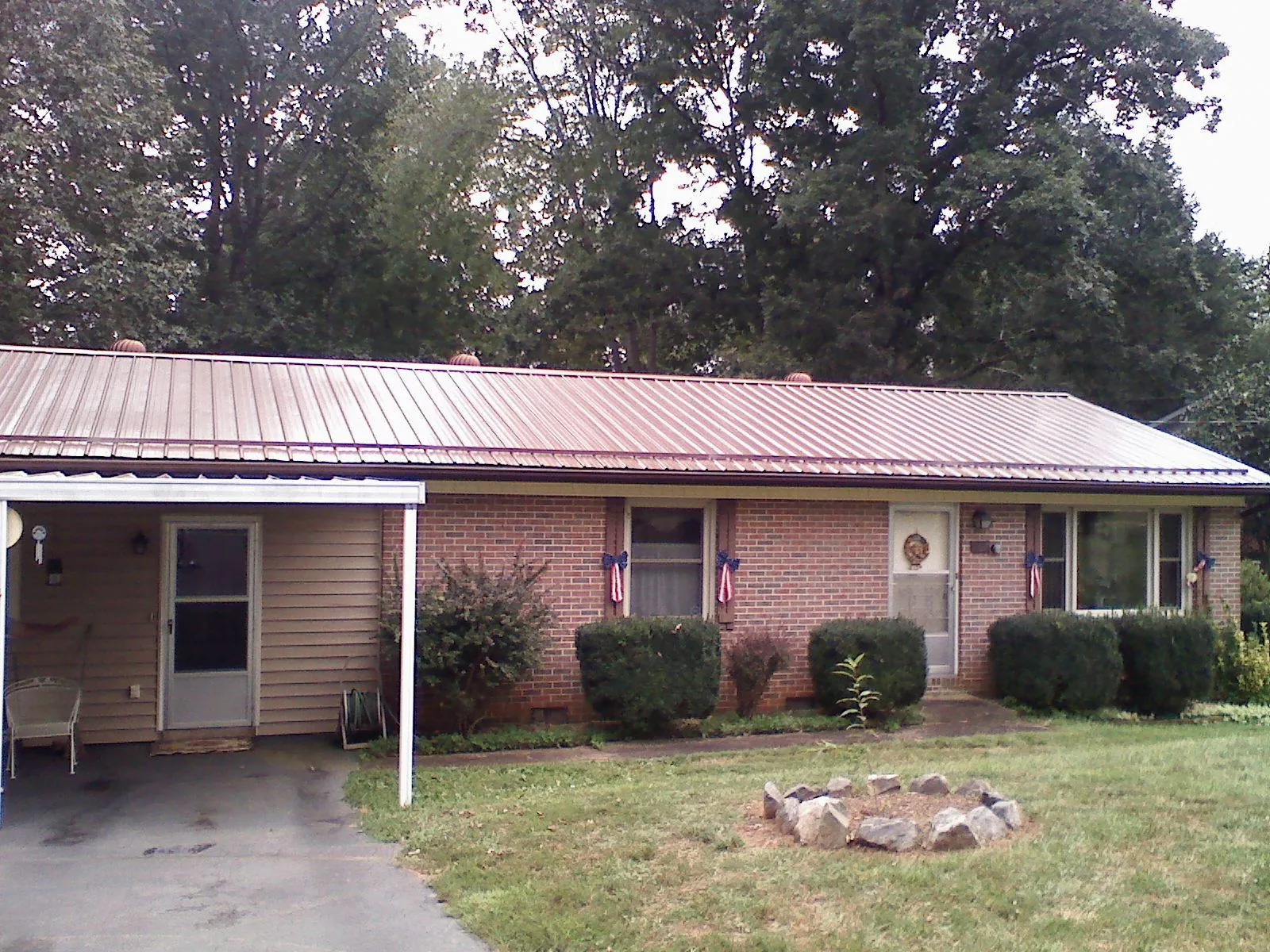 Bronze metal roof and carport on a brick ranch home — Roof Repair work by our crew in Bliss